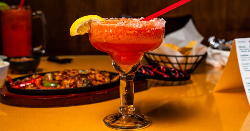 Frozen red cocktail beside a sizzling skillet