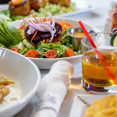 House salad served on the table with  other dishes and drinks.