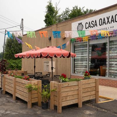 Exterior featuring a storefront with wooden planter boxes and patio umbrellas.