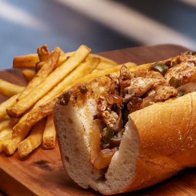 Philly cheesesteak sandwich with fries.