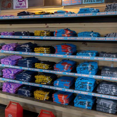 Interior, retail shelves with Dave's BBQ t shirts.
