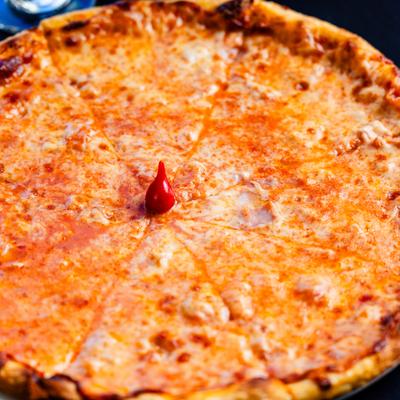 Classic cheese pizza with golden melted cheese and single red pepper garnish centered.