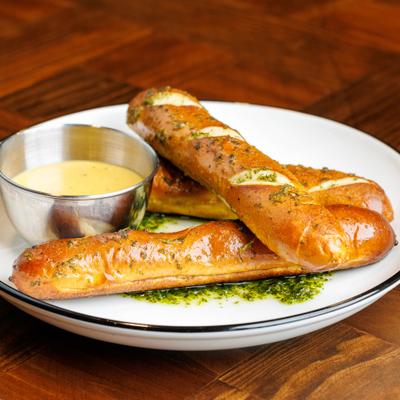 Soft pretzel sticks served with cheese dip.