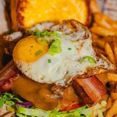 Johnny's Brunch Burger topped with fried egg, close-up.