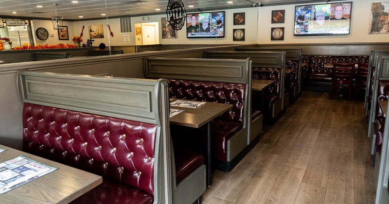Interior, dining area, leather padded seating booths with tables, TV on the wall