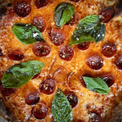 Pepperoni pizza, with tomato sauce, mozzarella, and basil.