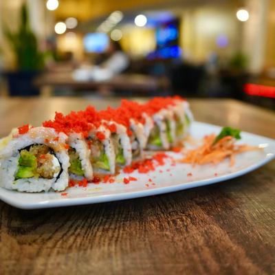 A plate of sushi rolls with avocado, creme cheese, and masago.