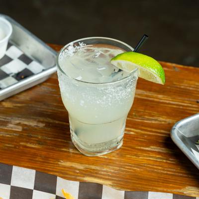 Margarita cocktail with salt rim and lime wedge garnish.