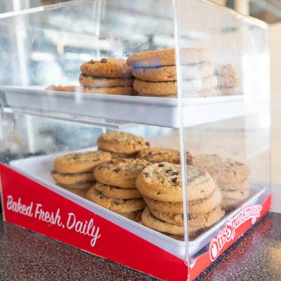 Chocolate chip cookies in a clear display case.