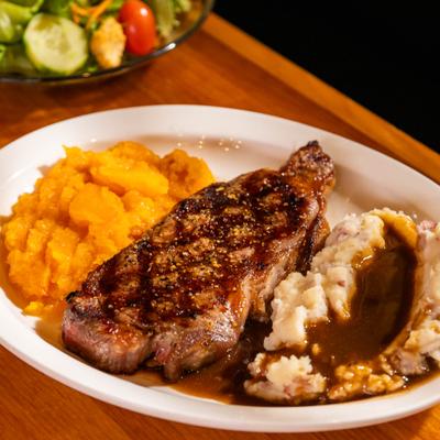 NY Strip Sirloin with sides of mashed potatoes.
