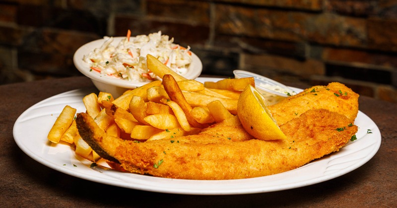 Fried fish served with fries, coleslaw and lemon