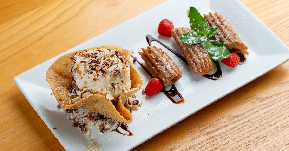 Churro sundae featuring churros served with a scoop of ice cream in tortilla shell