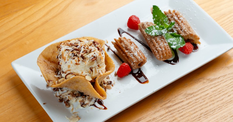 Churro sundae featuring churros served with a scoop of ice cream in tortilla shell