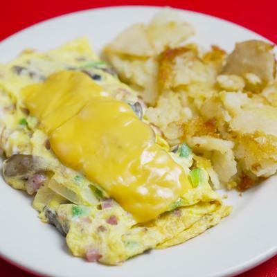 Western Omlette topped with melted cheese and served with home fries.