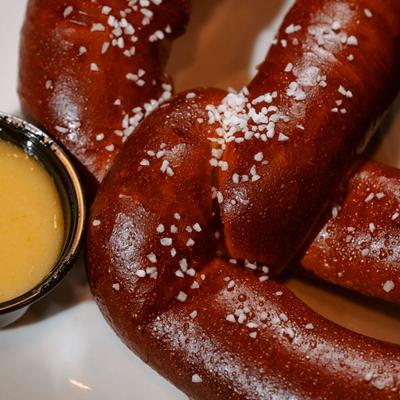 Soft pretzels served with a cheese dip, close-up.