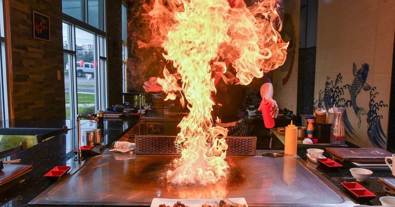 A chef performing a teppanyaki cooking show