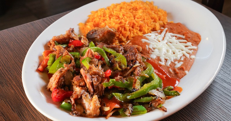 Cooked pork, with bell peppers, rice, and beans