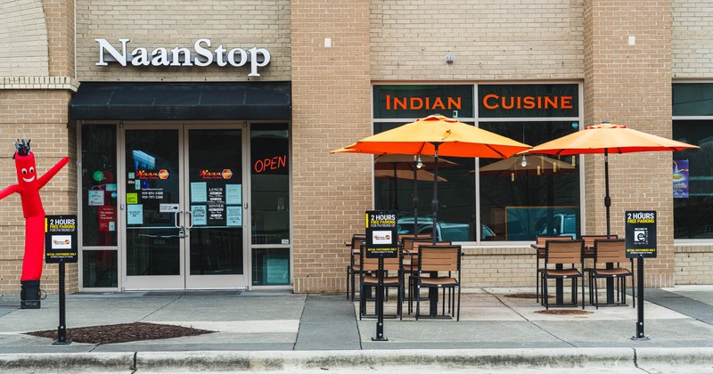 Exterior of a restaurant, outdoor seating and bright orange umbrellas