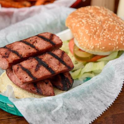 Smoked sausage sandwich, with lettuce, tomato, onion, and pickles.
