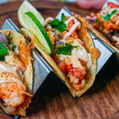 Shrimp taco and lobster taco topped with cilantro and creamy sauce.