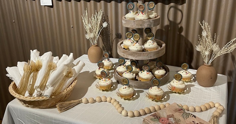 Dessert display table featuring a rustic three-tiered cupcake stand
