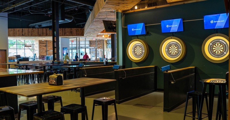 Interior, high seating area, tables with stools, dart lanes, concrete flooring