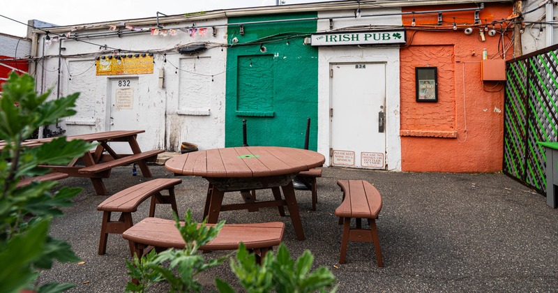 Colorful outdoor seating area, round wooden table and benches