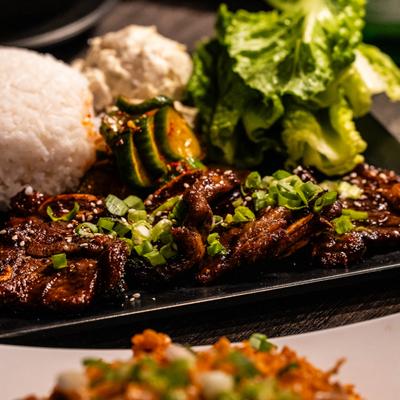 Korean-style short rib plate with various sides served on the table.