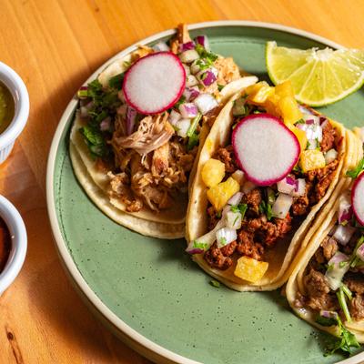 Street soft tacos with red and green salsas.