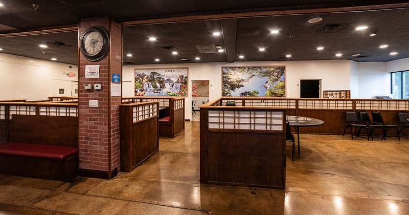 Interior with wooden booths, brick column with clock and large landscape images on the walls