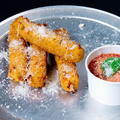 Mozzarella sticks with grated Parmesan cheese and a cup of marinara sauce.