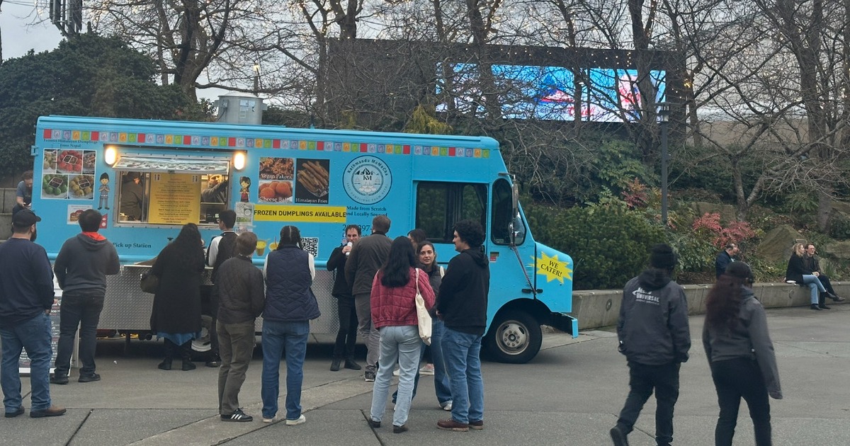 People waiting in front of a blue food truck