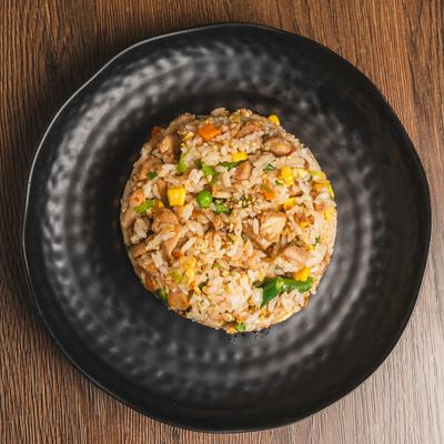 Chicken Fried Rice served on a black ceramic plate with a textured rim.