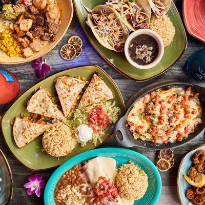 Assortment of Mexican dishes displayed on a table, overhead view.