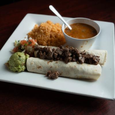 Carne Asada Enchilada served with dip, rice, guacamole and pico de gallo.