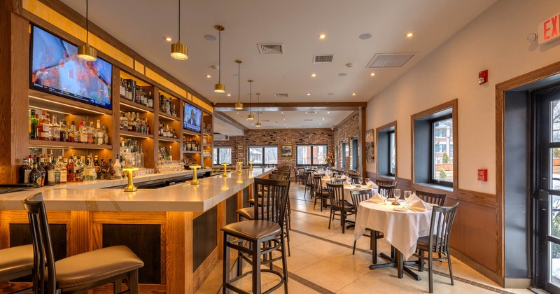 Interior, bar and dining area, bar with stools, tables for four on the right