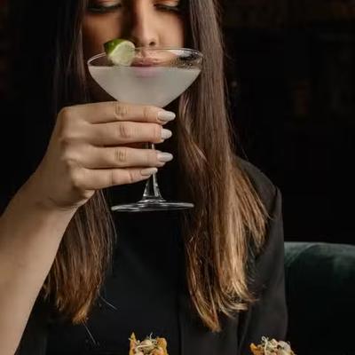 A lady sipping a cocktail.