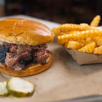 Sandwich with burnt ends and fries.