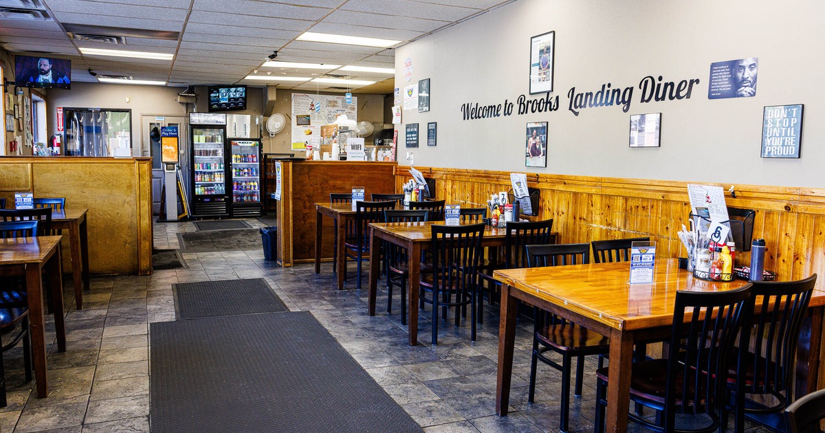 Casual diner interior with wooden tables and black chairs