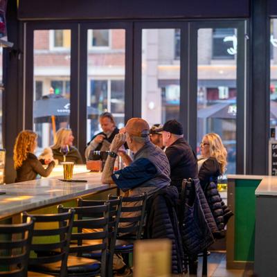 A cozy bar scene with people seated at a counter.