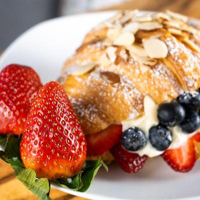Croissant with cream, berries, and almonds.