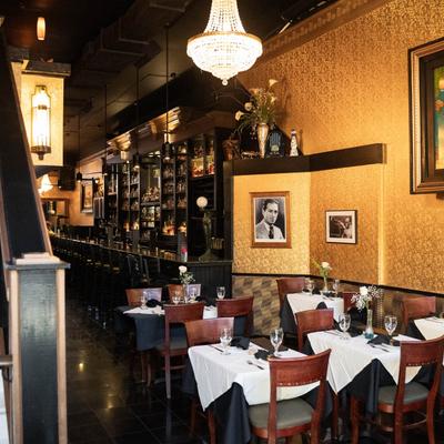 Dining tables, the bar is at the back, and the stairs to the upper floor are on the left.