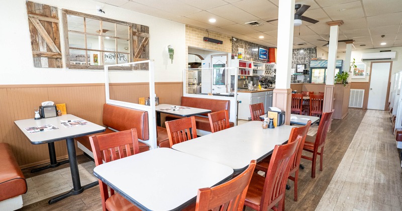 Casual diner interior with wooden tables and chairs, and leather booths