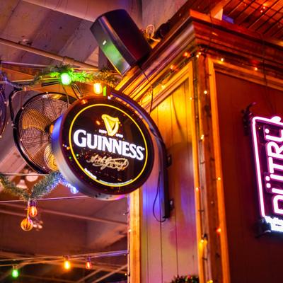 Interior with several neon signs, advertising beer.
