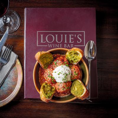 Meatballs with tomato sauce, whipped ricotta, and pesto rubbed crostini.