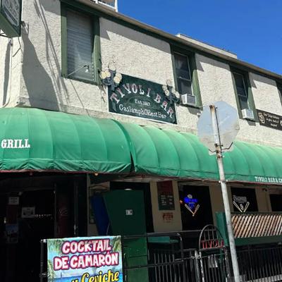 Exterior with green awning, patio, entrance and signs.