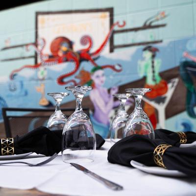 table set in patio with Gershwin's mural in the backround.