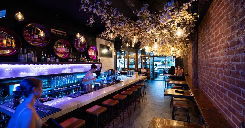 Interior, bar area, tables and chairs on the right, bar and bar stools on the left