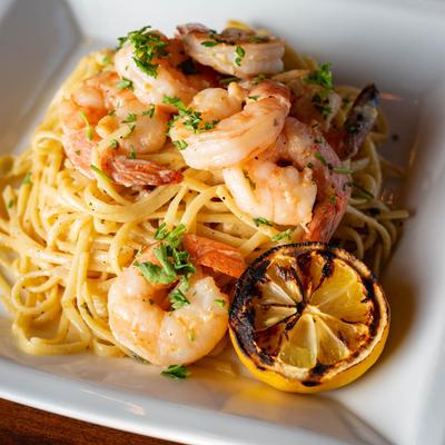 Shrimp Scampi with linguine and grilled lemon half.