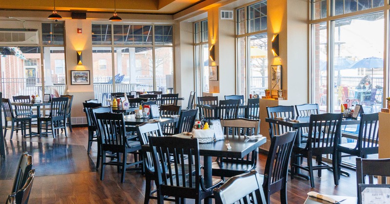 Interior, wide view of dining area, tables and chairs ready for guests